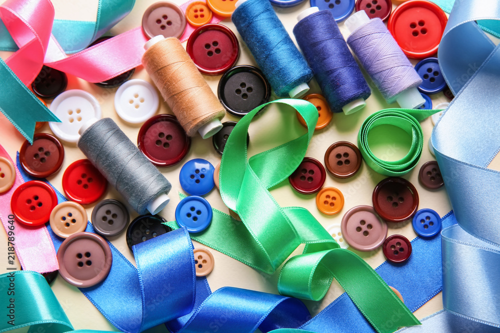 Different ribbons with threads and buttons on light background