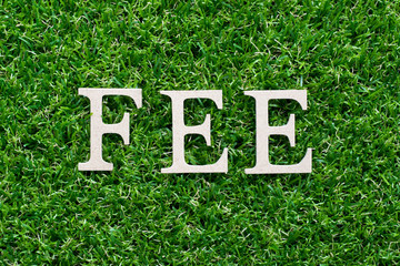 Canvas Print - Wood alphabet in word fee on artificial green grass background