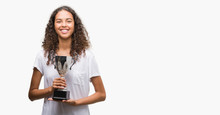 Young Hispanic Woman Holding Trophy With A Happy Face Standing And Smiling With A Confident Smile Showing Teeth
