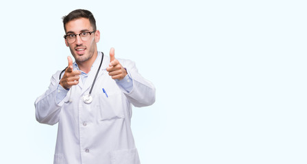 Poster - Handsome young doctor man pointing fingers to camera with happy and funny face. Good energy and vibes.