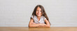 © Krakenimages.com - Young hispanic kid sitting on the table at home with a happy and cool smile on face. Lucky person.