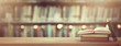 back to school concept. stack of books over wooden desk in front of library.
