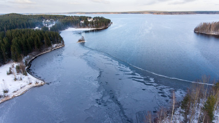 Wall Mural - Aerial view of partially frozen lake and forest on cold winter day, northern Karelia, Russia