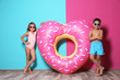 © New Africa - Cute little children with bright heart shaped inflatable ring near color wall