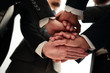 © ASDF - Close-up of businesspeople stacking hands in meeting