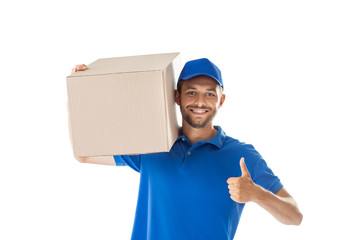 Canvas Print - Smiling young delivery man with parcel box showing thumbs up