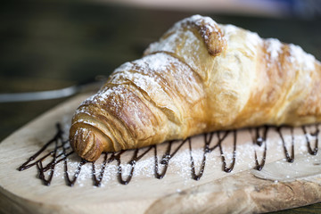 Slate plate with tasty croissants on table