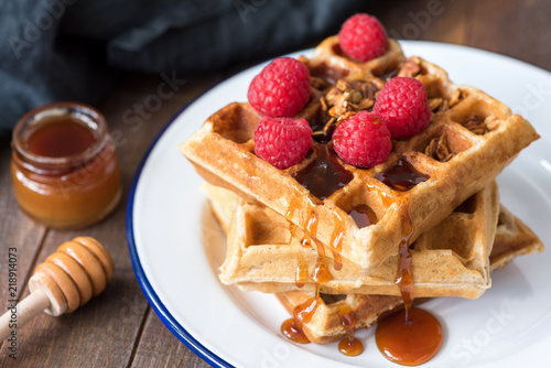 Fotografía Belgian waffles with honey and berries on white plate, closeup view