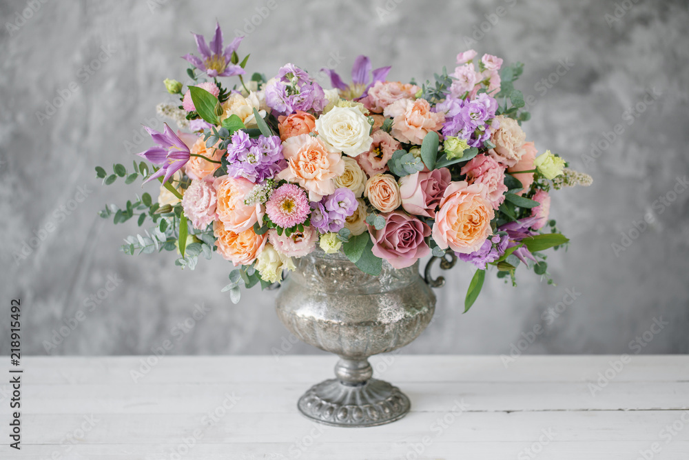 Gorgeous bouquet of different flowers. floral arrangement in vintage metal vase. table setting. lilac and peach color - obrazy, fototapety, plakaty 