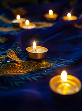 Flame Candle Lamps For The Evening Prayers. Diwali Lighting On Blue Sari With Golden Embroidery