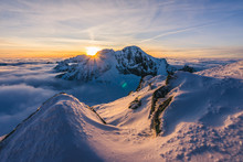 Stunning Sunset Or Sunrise In Winter Alpine Like Snow Landscape. Inversion, Sun Star Peaking Behind High Rocky And Icy Summit. Purple, Pink, Blue And Orange Colors. Ladovy Stit In Winter High Tatras.
