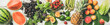 Summer food background. Flat-lay of seasonal fruit, vegetables and greens over white wooden background, top view, horizontal composition. Vegetarian, vegan, dieting, clean eating ingredients