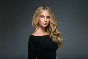 blonde hairstyle woman beauty with long curly blonde hair over dark background