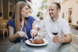 © VAKSMANV - Cheerful couple in a restaurant with glasses of red wine.  Young