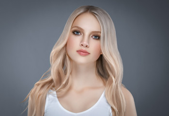 Beautiful Woman Face Portrait Beauty Skin Care Concept with long blonde hair  over gray background