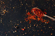 Saffron spice in spoon with empty space for text on dark black background. Seasonings for food. Close-up. Top view
