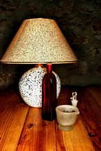 A Reading Lamp On A Table Of Wood And Herbs. Glass Grinder, Old Bottle For Drops And Red Tin For Bottle.