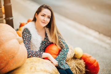 autumn portrait of young happy woman on farm market