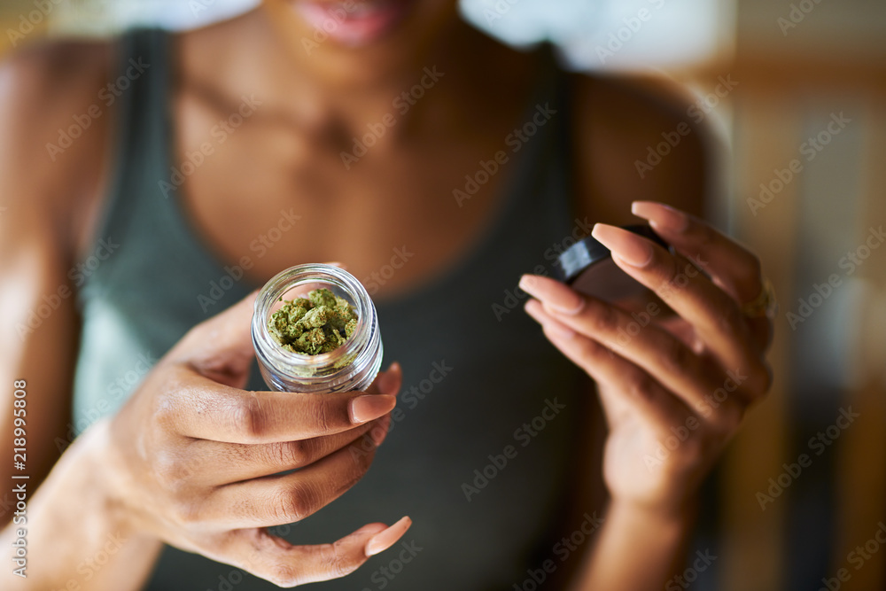 african american woman opening bottle of legal marijuana from dispensary close up - obrazy, fototapety, plakaty 