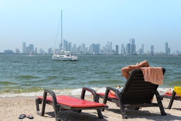 Wall Mural - resting on the beach on the other shore of the Bay of Cartagena with modern city in the background. Colombia