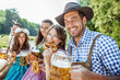 © karepa - Freunde Trinken Bier in der Bayerischer Tracht an der Isar