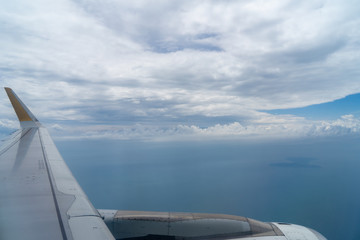 Wall Mural - view of beautiful white cloudscape with shades of blue sky and deep ocean background from flying pla