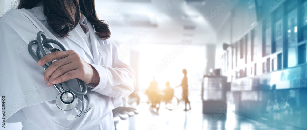 Female doctor in confident with stethoscope in hand on hospital background - obrazy, fototapety, plakaty 