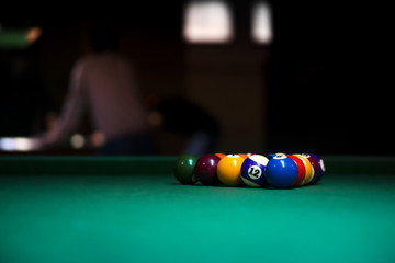 Wall Mural - Sport billiard balls on green billiard table in pub. On going billiard game. Competitive players trying to find out the winner of the round