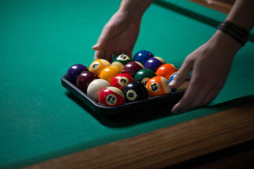 Wall Mural - Sport billiard balls set and a chalk in a box on green billiard table in pub. Players are ready for the round to start the billiard game  
