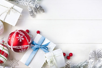 Wall Mural - christmas festive composition. christmas gift with blue ribbon, white fir branches and cones, red be