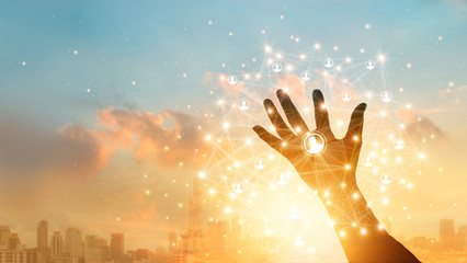 Leinwandbilder - Businessman touching icon customer in hand with global network connection and data exchanges worldwide on city sunset background. Networking and technology concept