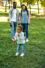 Wall Mural - african american daughter blowing soap bubbles in park