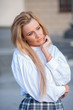 © Михаил Решетников - pensive young blond woman on building background with columns. sad girl in a white blouse