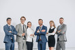 © LIGHTFIELD STUDIOS - smiling businesspeople with crossed arms posing near board after training in hub