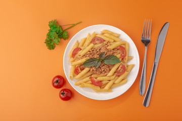 Wall Mural - Pasta Fettuccine Bolognese with tomato sauce and basil in white dish on the orange background.