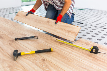 Wall Mural - Handyman installing new laminated wooden floor