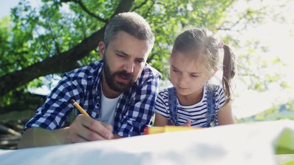 Wall Mural - Father with a small daughter outside, making sketches.