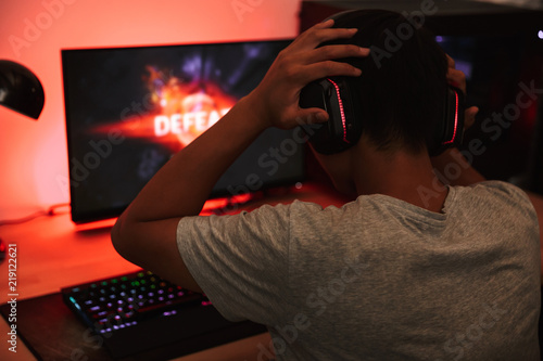 Portrait From Back Of Teenage Gamer Boy Playing Video Games