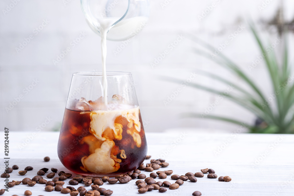 cold brew coffee with milk on white wooden table - obrazy, fototapety, plakaty 