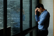 © bongkarn - Tired Asian businessman standing in side of the big window in office