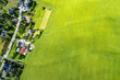 Luftaufnahme eines Dorfes und einer großen grünen Wiese