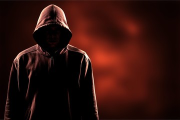 Thief in black clothes on grey background