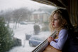 © Johanna King - Little girl looking out the window at the snow