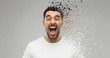 emotions, stress and people concept - crazy shouting man in t-shirt over gray background with particle dispersion effect