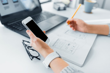 app design, technology and business concept - web designer or developer with smartphone working on u