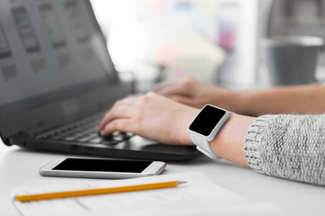 Wall Mural - app design, technology and business concept - designer with smart watch and laptop at office