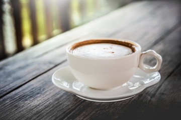 Cup of coffee on wooden table in morning.