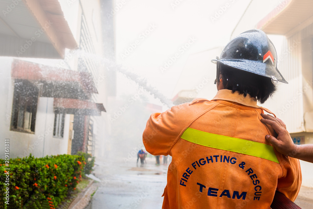 Fireman or fie fighting rescue team using water and extinguisher ...