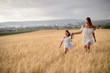 © Inna Darda - Beautiful family in a field of rye at sunset. A woman and child in amazing clothes walking through the field of rye.