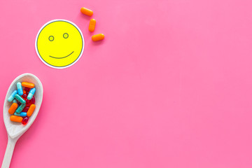 Sticker - Reception of medicines concept. Recovery. Pills in spoon near smile face emoji on pink background top view copy space